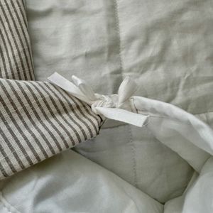 A green striped duvet cover, partially inside out, is tied, using the new fabric tape strips, to a loop on the weighted blanket.